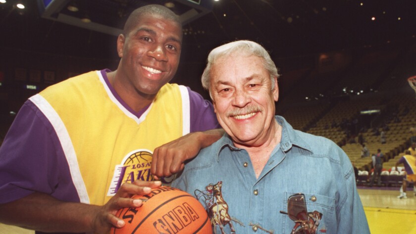 Magic Johnson poses with Jerry Buss before a Lakers game.