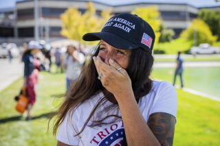 A woman covers her mouth with one hand.