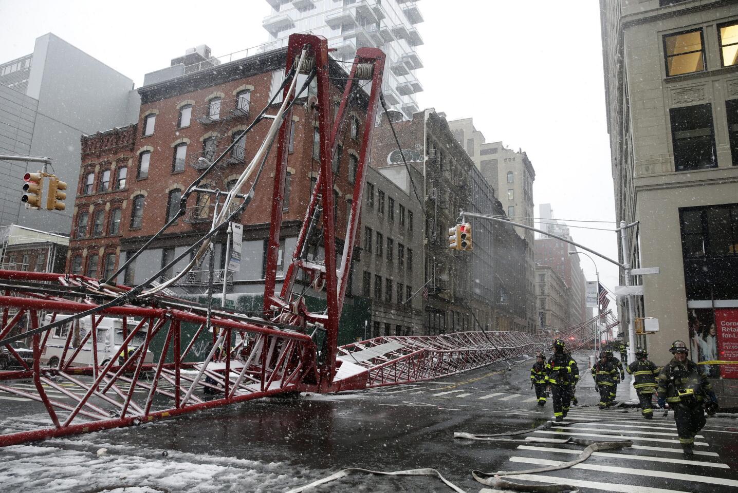 Members of the New York City Fire Department survey the damage of a fallen crane on 40 Worth Street in Lower Manhattan in New York City on Feb. 5, 2016. One person was killed and three others injured in the incident.
