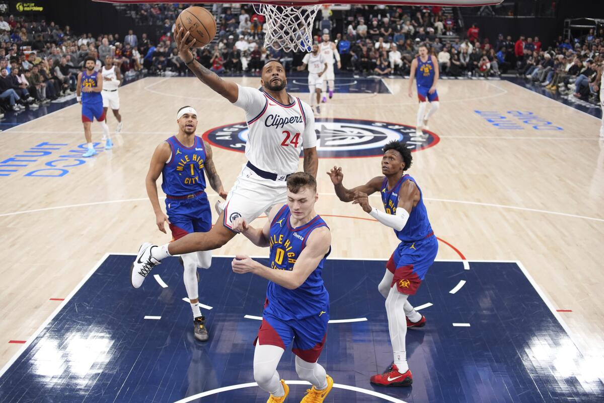 Norman Powell goes in for a layup while surrounded by three Nuggets defenders.