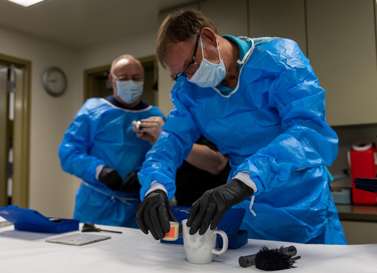 Steve Randall uses tape to lift fingerprints as instructed during a session of the Costa Mesa Citizen's Police Academy.