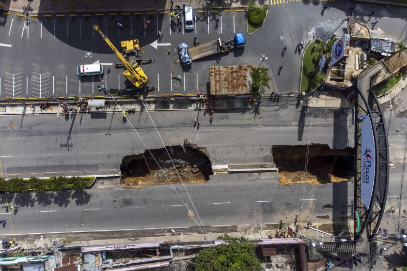 Vista de un socavón en la carretera principal de Villa Nueva, Guatemala, el domingo 25 de septiembre de 2022. (AP Foto/Moisés Castillo)