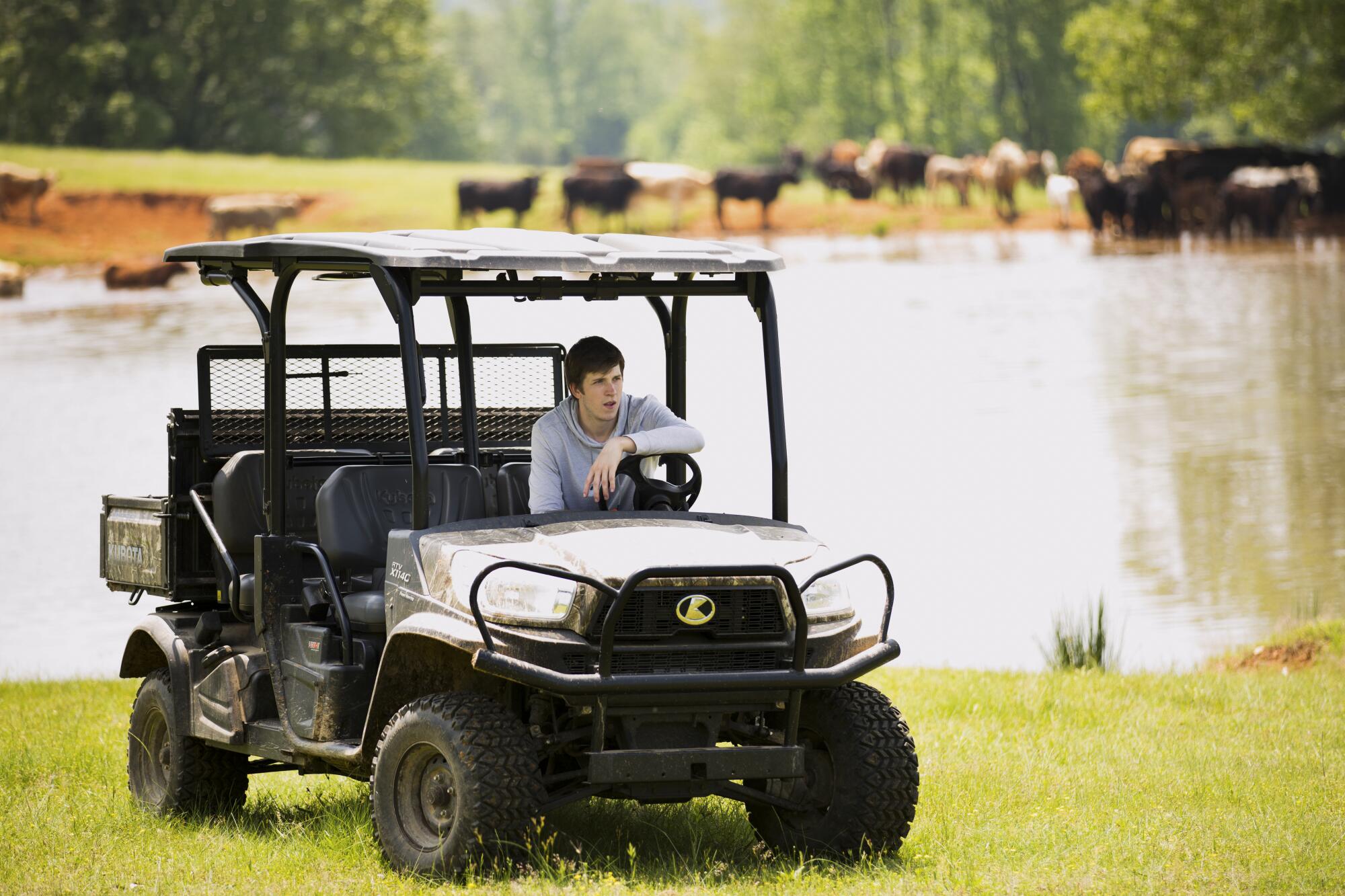 Austin Reaves drives around a pond on his mother's farm in Newark, Ark.