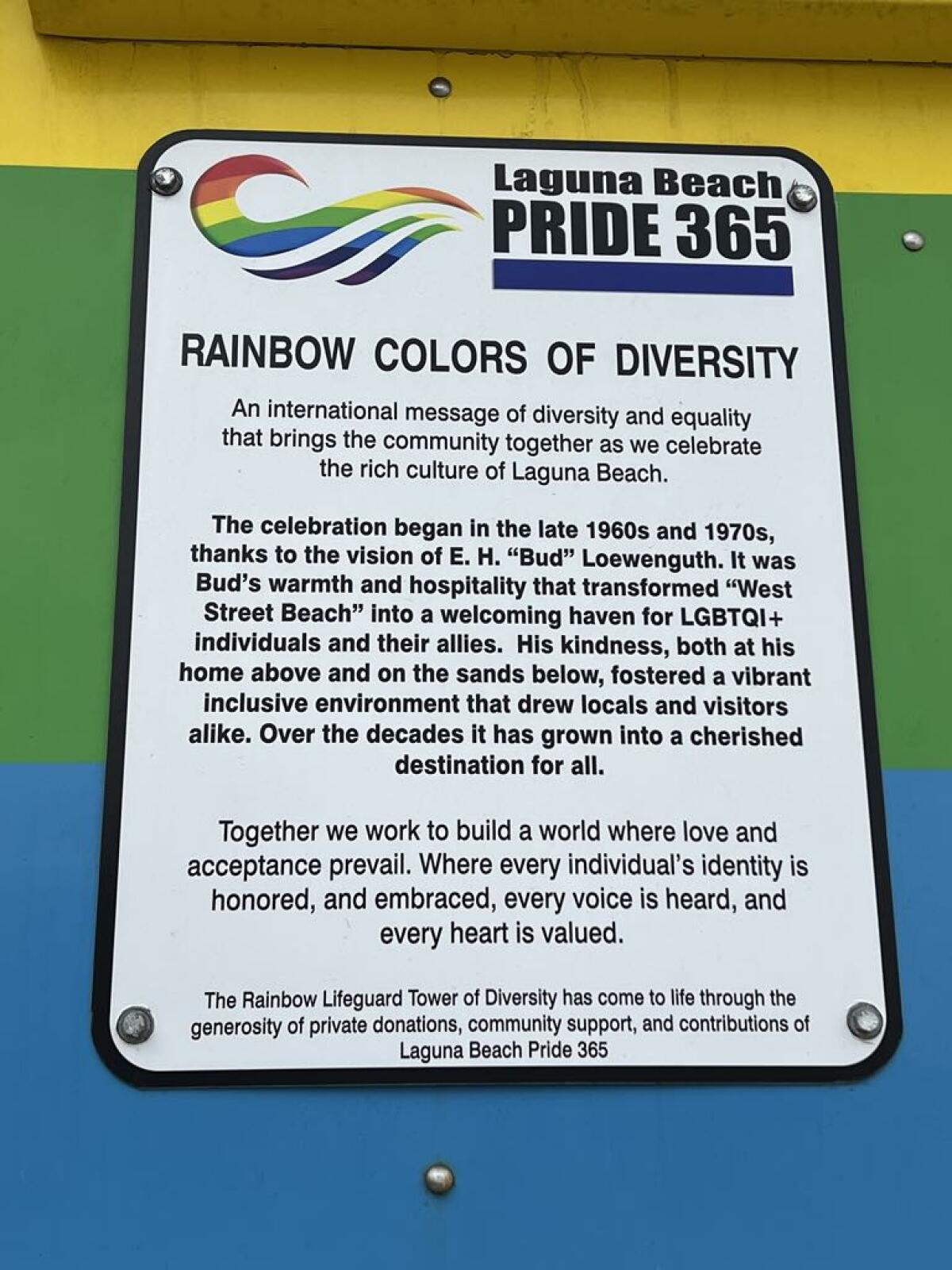A plaque explaining the rainbow colors of diversity and honoring E.H. 'Bud' Loewenguth at Laguna's rainbow lifeguard tower.