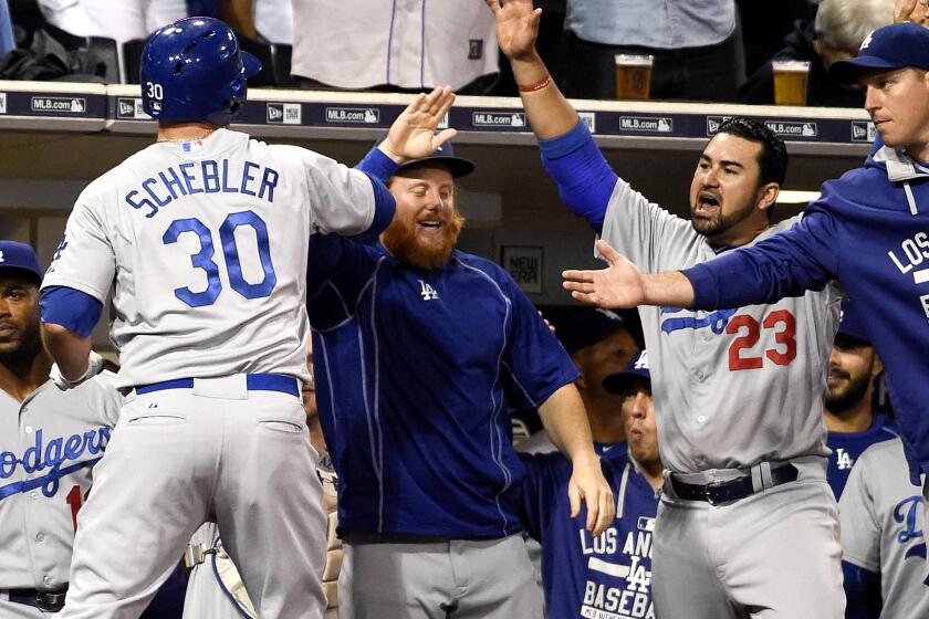 Dodgers right fielder Scott Schebler (30) is congratulated in the dugout by teammates after hitting a solo home run against the Padres in the second inning Friday night in San Diego.