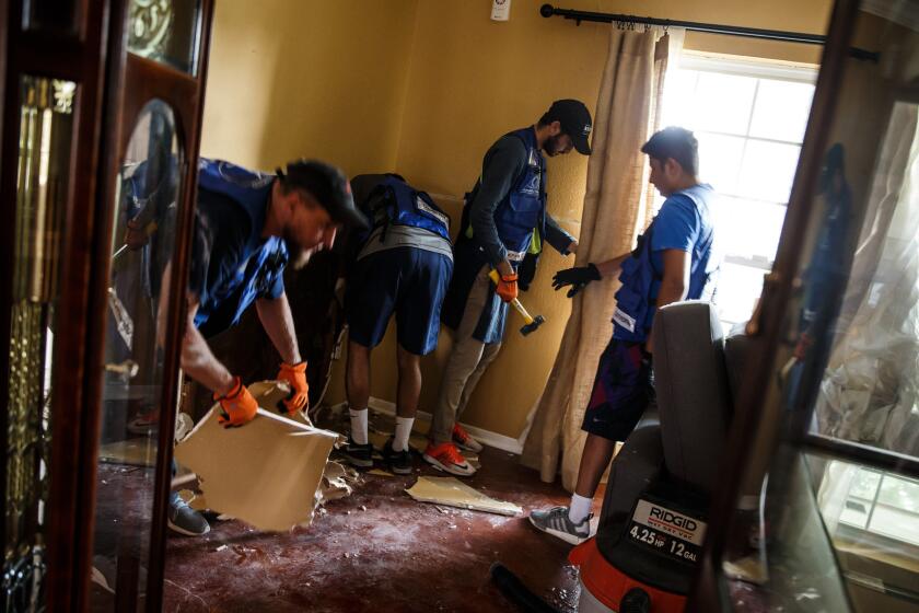 HOUSTON, TEXAS -- FRIDAY, SEPTEMBER 1, 2017: Volunteers from the Ahmadiyya Muslim Youth Association, Yusuf Seager, from left, Rahib Ahmed, Rahman Nasir, and Khalil Nasir help tear out dry walls that have been damaged by floodwater in Westbury neighborhood in Houston, Texas, on Sept. 1, 2017. It is also the Islamic holiday of Eid-al-Adha. The young men are spending the Islamic holiday of Eid-ul-Adha to help victims in Houston recover since Hurricane Harvey inundated the region with up to 50 inches of rain, causing widespread flooding, property damage and loss of life. (Marcus Yam / Los Angeles Times)