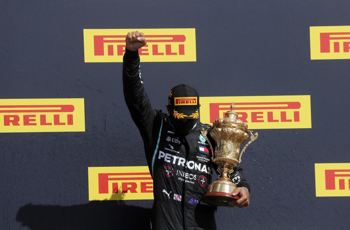 Lewis Hamilton holds his trophy on the podium after the British Formula One Grand Prix in Silverstone, England.