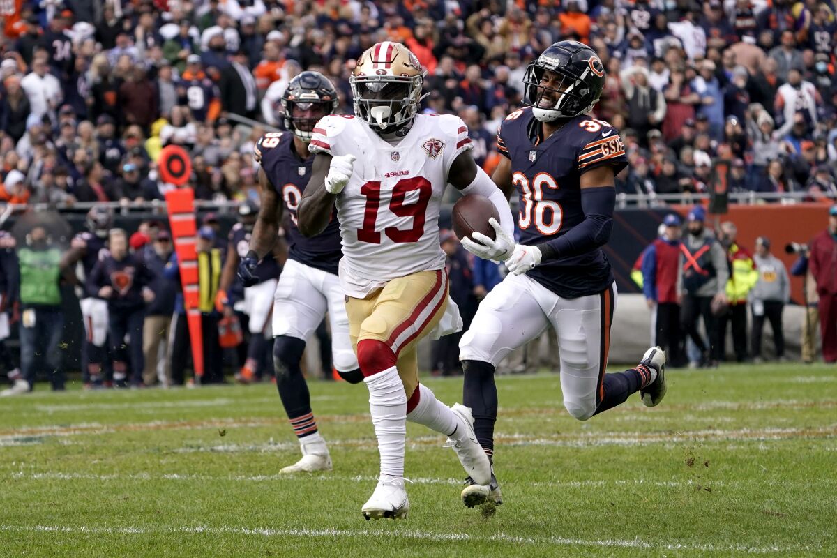 San Francisco 49ers wide receiver Deebo Samuel heads down the sideline past Chicago Bears linebacker Trevis Gipson (99) and defensive back DeAndre Houston-Carson for a big gain during the first half of an NFL football game Sunday, Oct. 31, 2021, in Chicago. (AP Photo/David Banks)