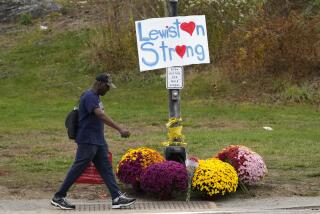 ARCHIVO - Un hombre camina frente a varios arreglos florales y un letrero de apoyo a la comunidad el 28 de octubre de 2023, tras el tiroteo masivo ocurrido el 25 de octubre en Lewiston, Maine. (AP Foto/Robert F. Bukaty, Archivo)