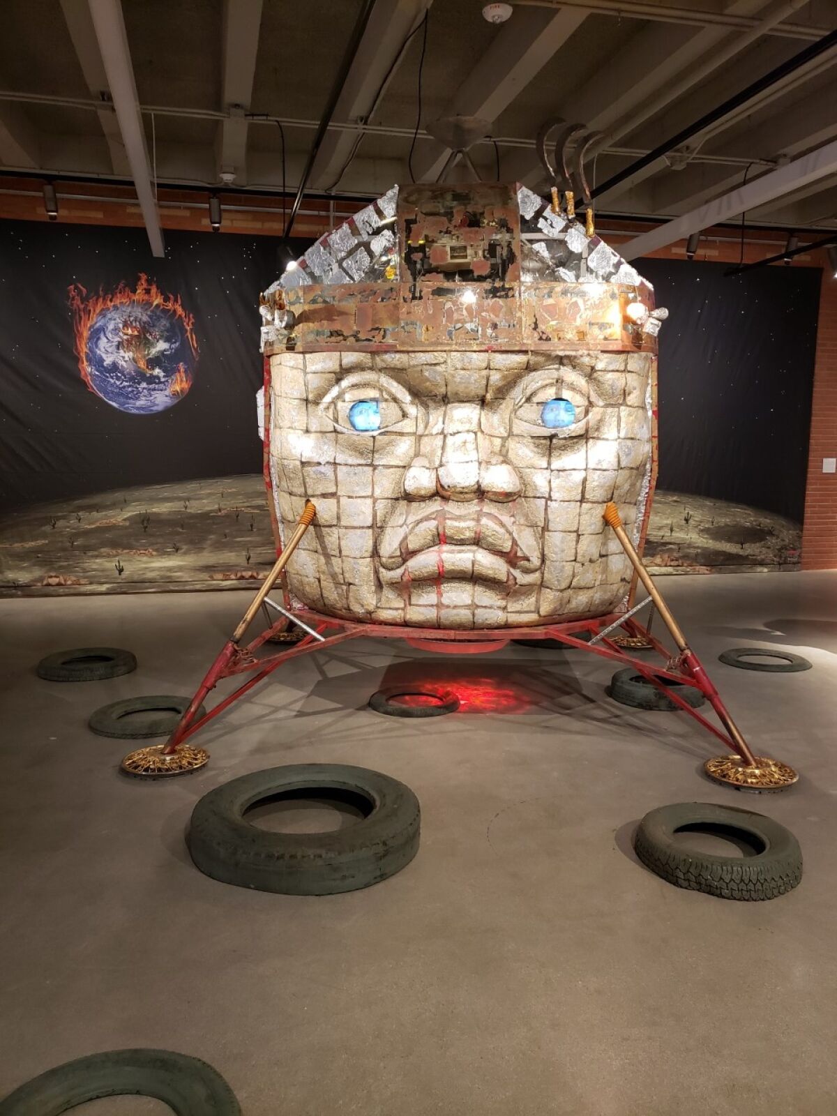 A sculpture of an Olmec head merged with a lunar landing vehicle.