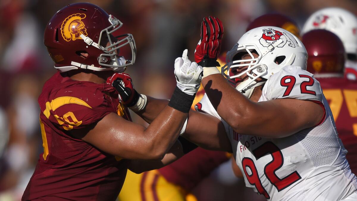 USC offensive guard Toa Lobendahn, left, battles Fresno State defensive lineman Tyeler Davison during the Trojans' 52-13 victory Saturday.