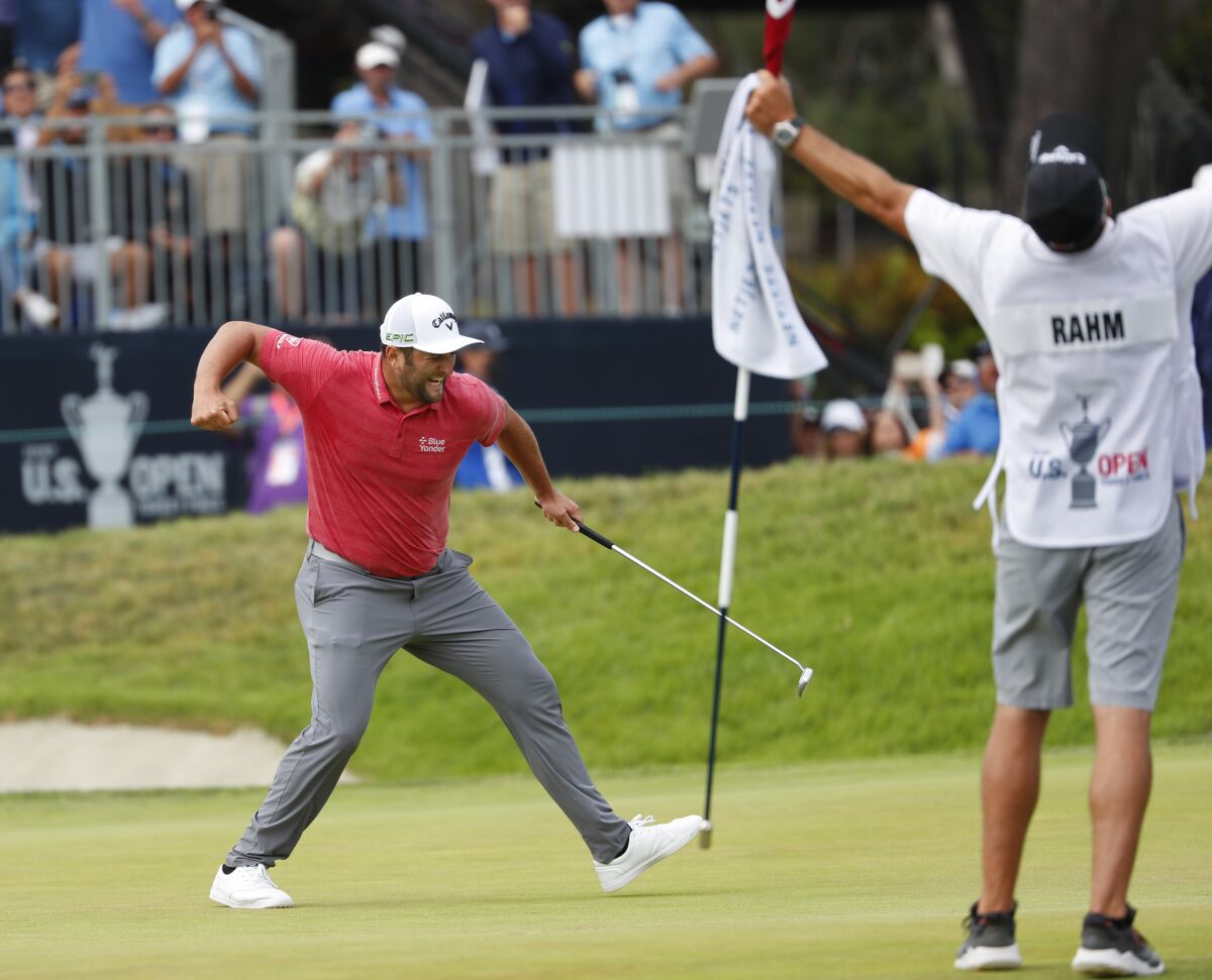Jon Rahm celebrates with caddie Adam Hayes after sinking a birdie putt on the 18th hole as he won the U.S. Open in La Jolla.