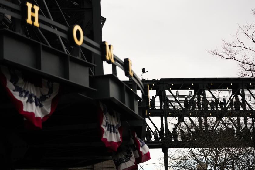 Los aficionados cruzan un puente para presenciar el juego inaugural de la campaña de los Marineros de Seattle, ante los Medias Rojas de Boston, el jueves 28 de marzo de 2024 (AP Foto/Lindsey Wasson)