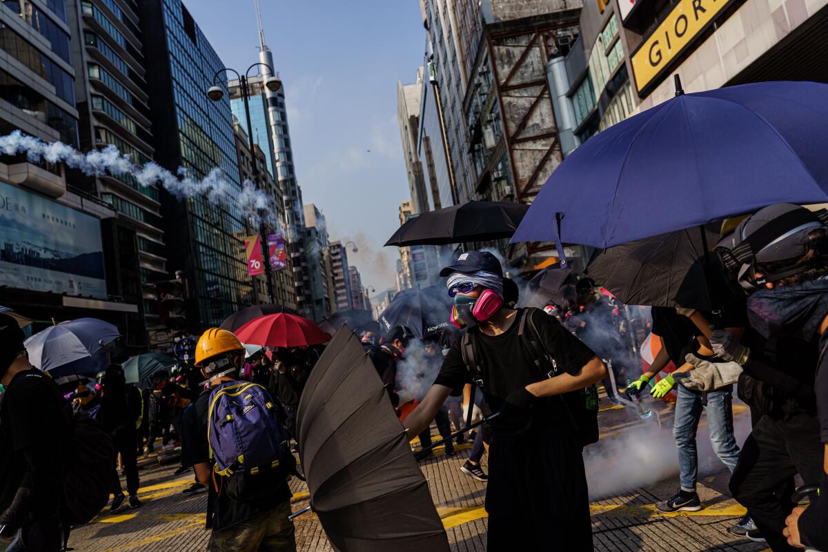 Protesters dodge tear gas canisters