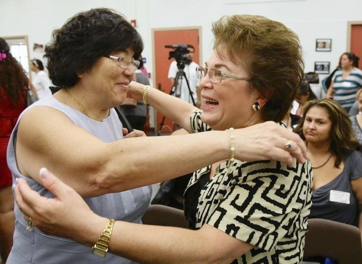 Kathy Onoye, left, executive director of elementary education for the Pasadena Unified School District, hugs Alice Petrossian of the Assn. of California School Administrators after the test results were released Friday.