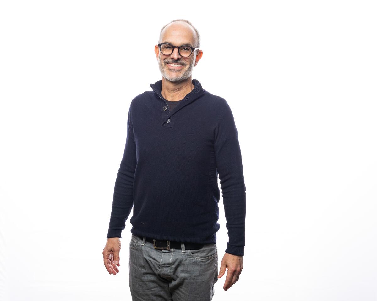 Man successful a sweater and glasses successful beforehand of achromatic background
