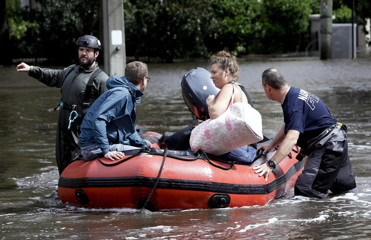 Rescue workers help a couple evacuate their home after it was flooded by Tropical Storm Irma in Jacksonville, Fla.