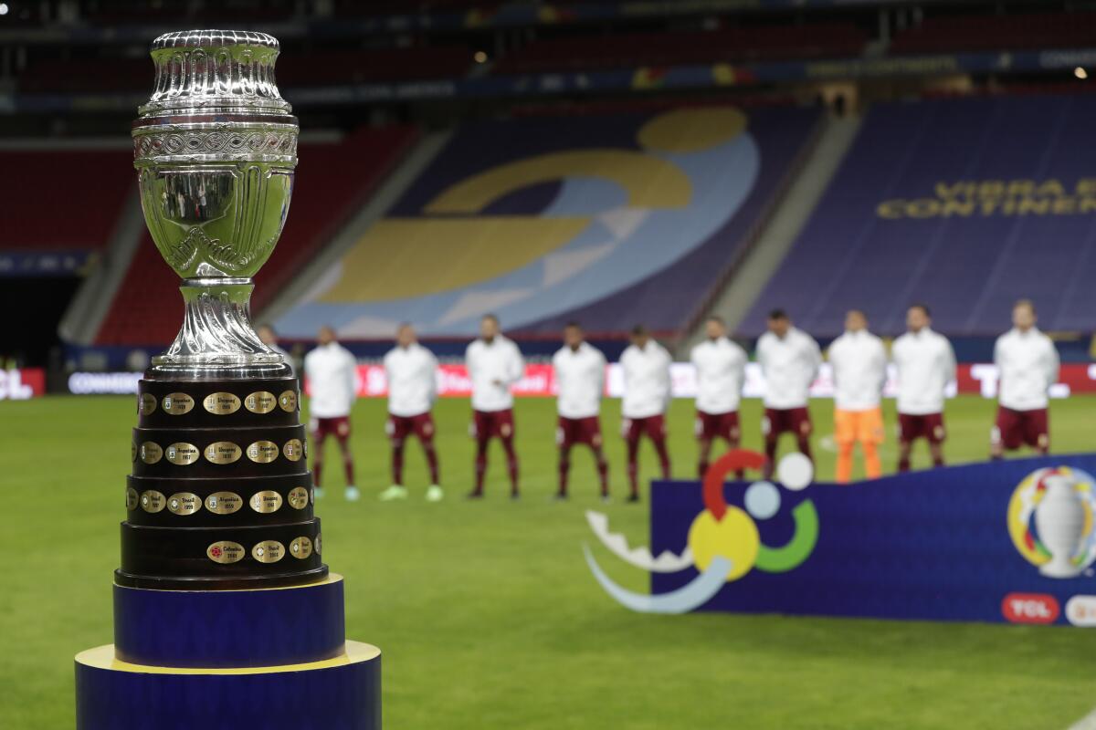 La foto del domingo 13 de junio de 2021 muestra el trofeo de la Copa América, delante de los jugadores de Venezuela.