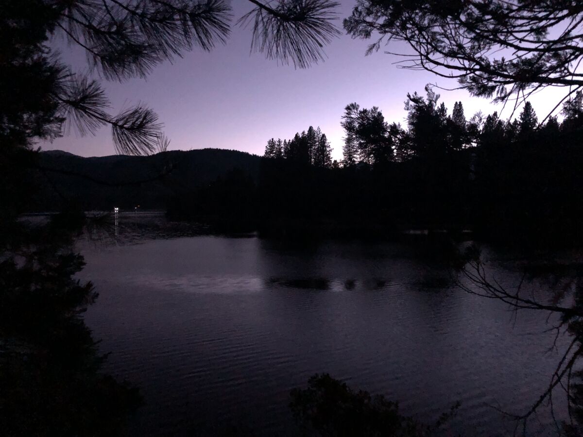A darkened lake, with some light in the sky.