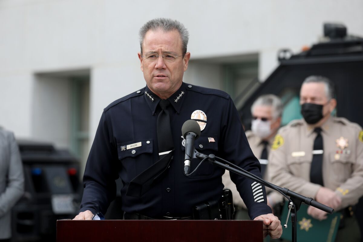 LAPD Chief Michel Moore speaking into a microphone