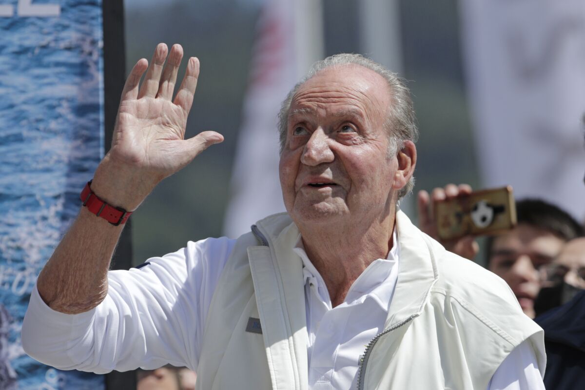 FILE - Spain's former King Juan Carlos waves before a reception at a nautical club prior to a yachting event in Sanxenxo, northwestern Spain, on, May 20, 2022. Spain’s former king has decided to postpone a second visit home since he established residence abroad after his reputation was tarnished by financial scandal, Spanish news agency EFE reported Tuesday, June 7, 2022. (AP Photo/Lalo R. Villar, File)