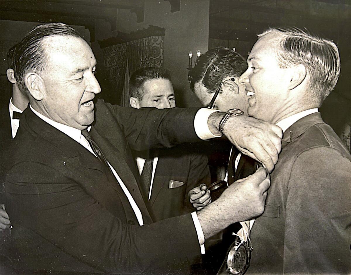 During a campaign event in 1966, then-Gov. Pat Brown, left, pinned a ribbon on the jacket of