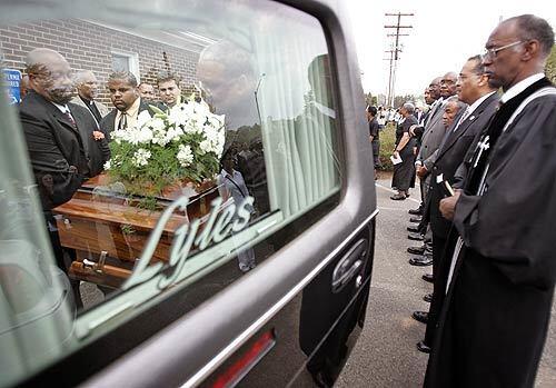 Erin Peterson's casket is placed inside a hearse as Rev. Dr. Eugene Johnson Pastor, right, looks on following funeral services Mount Olive Baptist Church in Centreville, Va. Peterson, a freshman majoring in international studies, was one of last week's shooting victims at Virginia Tech.