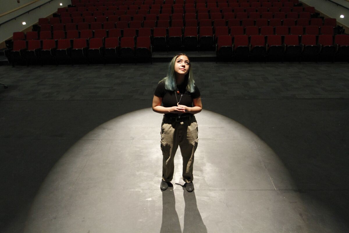 High school senior Helene Trujillo poses for a photo in the theater at Las Cruces High School on Thursday, Feb. 10, 2022, in Las Cruces, N.M. Trujillo said having at least one of her teachers be flexible with deadlines and revisiting lessons has helped her feel less "suffocated." A growing number of schools now are becoming more deliberate about eliminating bias from grading systems as a result of lessons from the pandemic and the nation's broad reckoning with issues of racial injustice following years of advocacy for "equitable grading." (AP Photo/Cedar Attanasio)