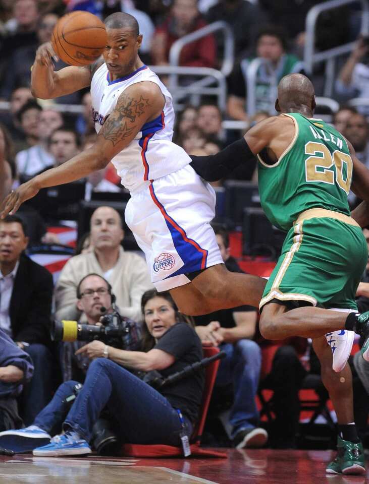 Clippers forward Caron Butler tries to save the ball from going out of bounds against Celtics guard Ray Allen on Monday night at Staples Center.