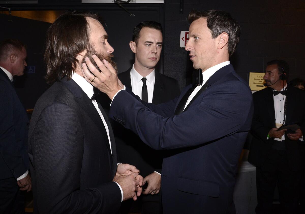 Seth Meyers is intrigued with Will Forte's scruffy beard at the 67th Primetime Emmy Awards. That's Colin Hanks looking on, center.