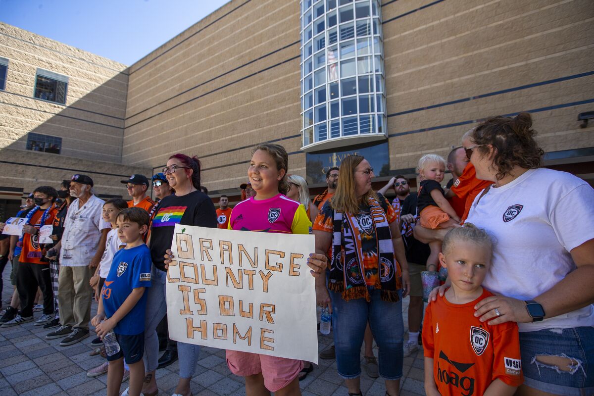 Supporters of the Orange County Soccer Club stand in front of Irvine City Hall on Tuesday.