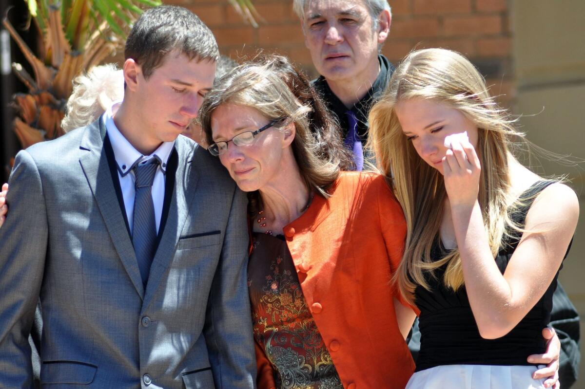 in Bloemfontein, South Africa, Yolande Korkie, flanked by her children Pieter-Ben and Lize-Marie, right, attends the funeral of her husband, Pierre Korkie, a hostage who was slain in Yemen. teacher who was held hostage in Yemen.