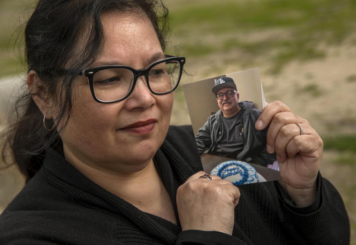 Maria Macias holds up  a photograph of her husband.