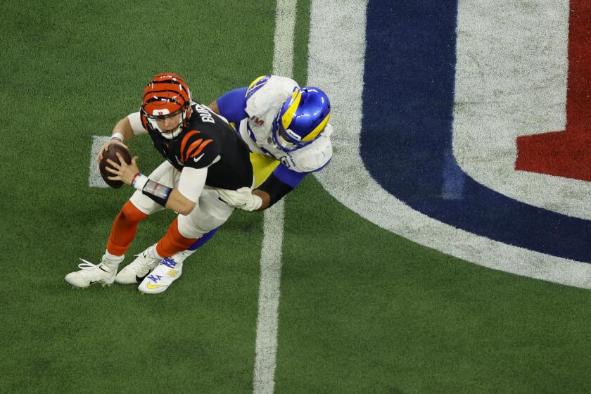 Rams defensive end Aaron Donald (99) pressures Bengals quarterback Joe Burrow (9) throw an incomplete pass