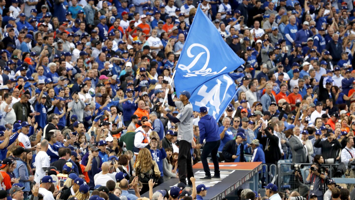 Lakers legendary basketball player Kareem Abdul-Jabbar waves the Dodgers flag to rally Dodgers fans.