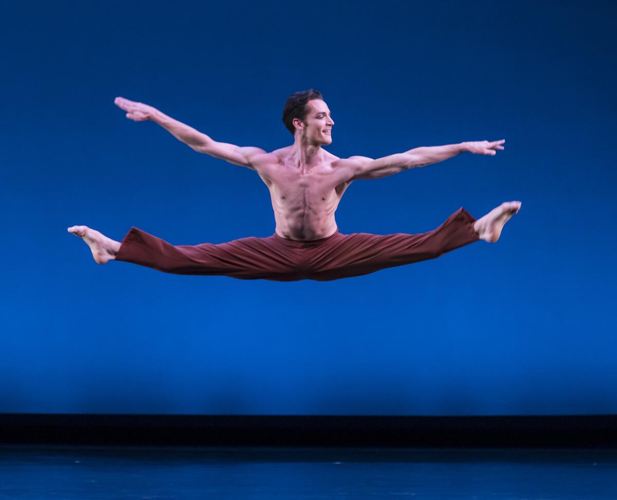 A dancer performs a split in midair