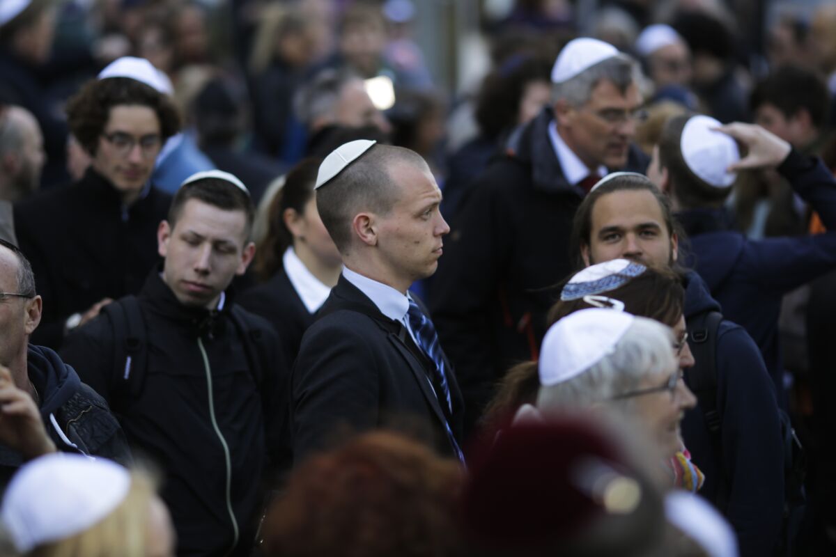 FILE - People wear Jewish skullcaps, as they attend a demonstration against an anti-Semitic attack in Berlin April 25, 2018. The leading dictionary of standard German has changed its definition of Jew, or "Jude" in German again, after a recent update caused an uproar in the country's Jewish community. (AP Photo/Markus Schreiber, File)