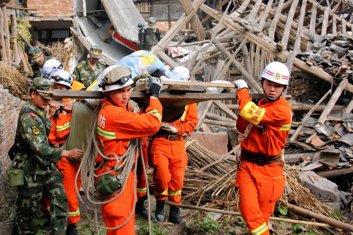 Rescuers carry an elderly man from his damaged home after an earthquake shook the Chinese city of Yaan and surrounding areas.
