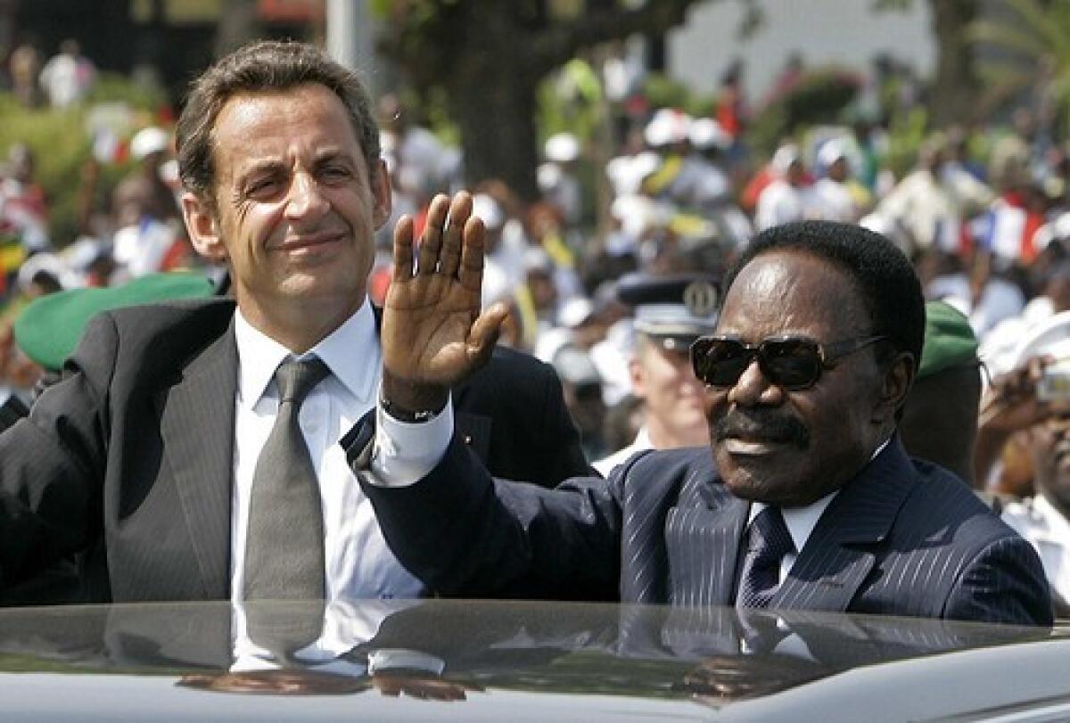 Gabon President Omar Bongo, right, and French President Nicolas Sarkozy wave to bystanders in Gabons capital, Libreville. Bongos 42-year rule faced little opposition.