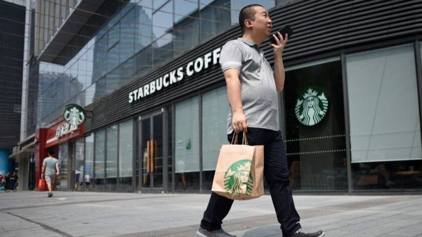 A man walks past a Starbucks coffee shop in Beijing in August 2018.