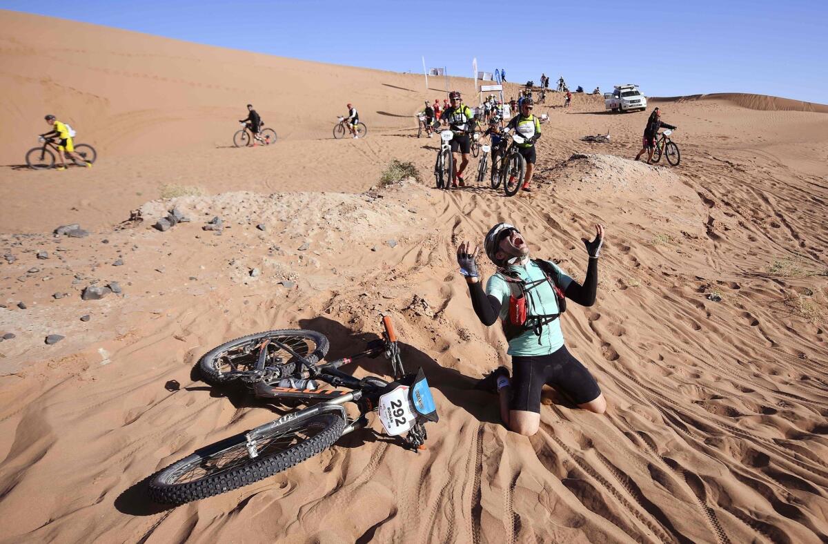 A competitor reacts after crossing a sand dune during Stage 4 of the 13th edition of the Titan Desert 2018 mountain biking race between Boumalne Dades and Merzouga in Morocco.