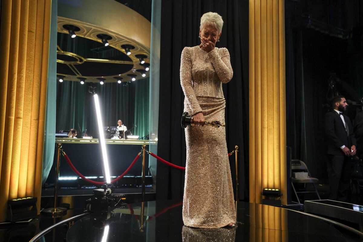  Jamie Lee Curtis places her hand on her mouth during an emotional moment backstage at the Oscars