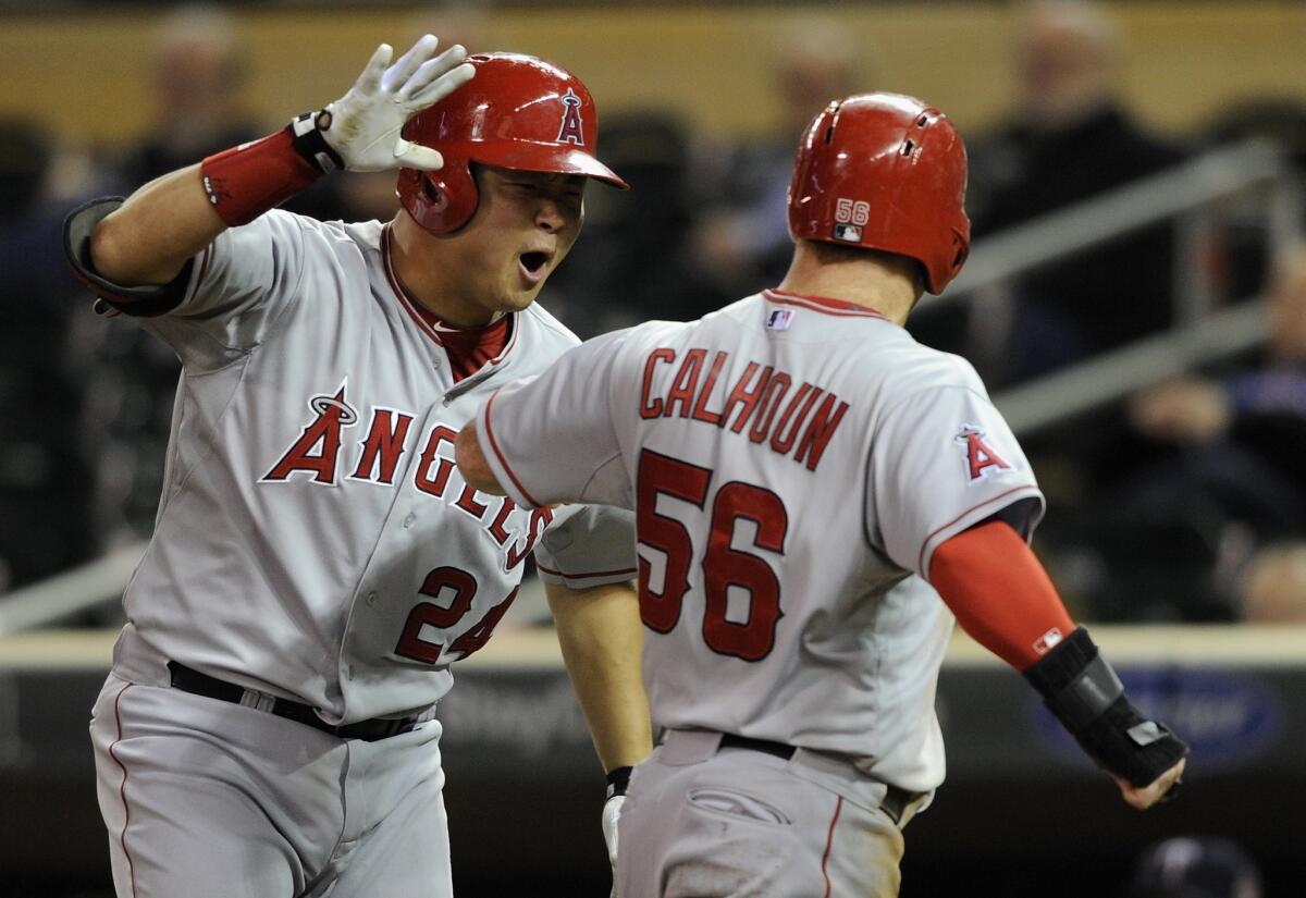 Hank Conger congratulates Kole Calhoun after scoring the go-ahead run in the 10th inning to give the Angels a 7-6 win Friday over the Minnesota Twins.