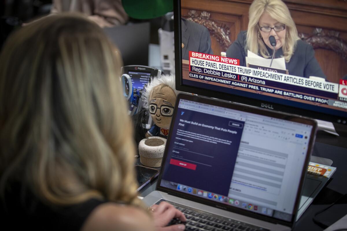 A Bernie Sanders doll sits next to Ana Kasparian as she works on the show that has five million subscribers.