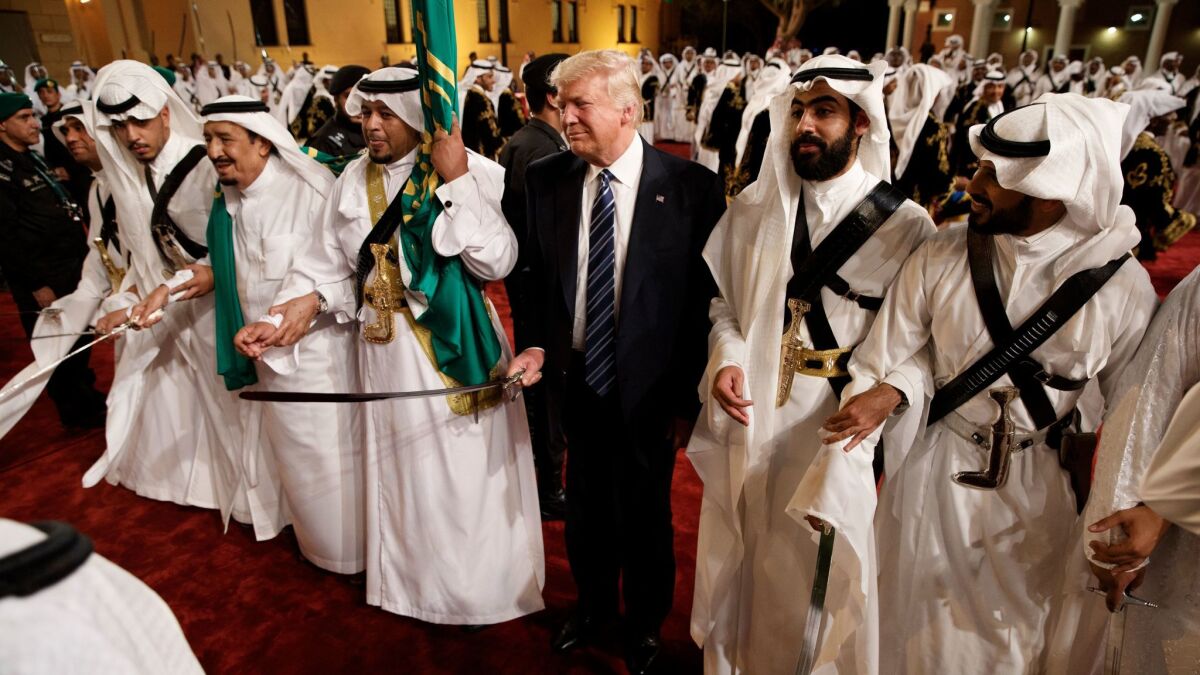 President Donald Trump holds a sword and sways with traditional dancers during a welcome ceremony at Murabba Palace on May 20, in Riyadh.