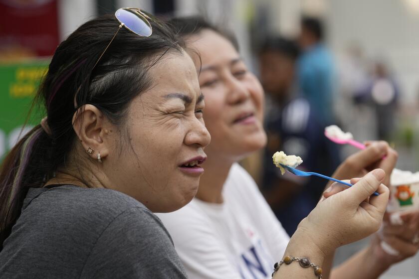 FILE - Women eat ice cream in Bangkok, Thailand, on April 9, 2024. Southeast Asia is coping with a weekslong heat wave as record-high temperatures have led to school closings in several countries and urgent health warnings throughout the region. (AP Photo/Sakchai Lalit, File)