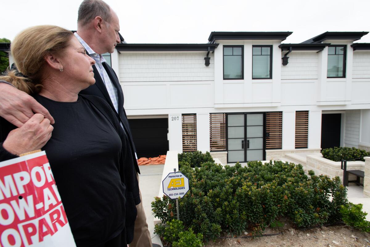Amy and Marshall Senk stand outside of their newly rebuilt home Friday, May 17.
