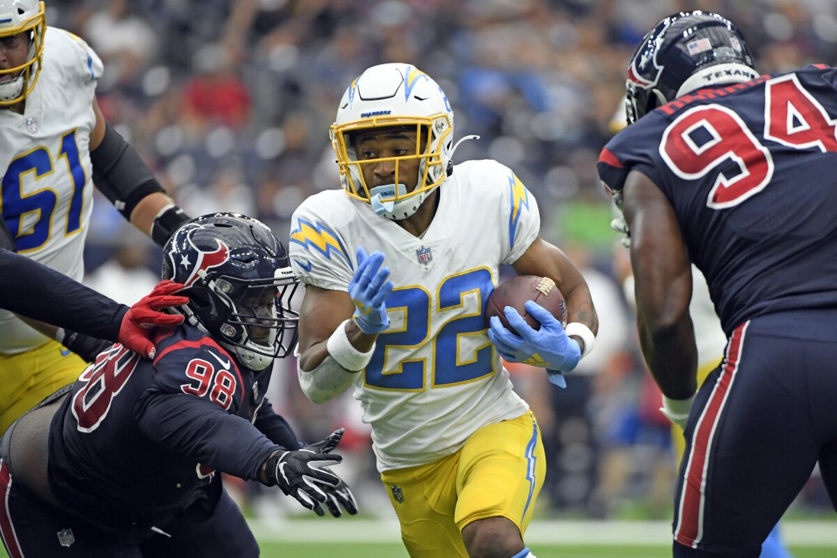 Chargers running back Justin Jackson runs for a touchdown as Houston Texans' Michael Dwumfour and Charles Omenihu defend.