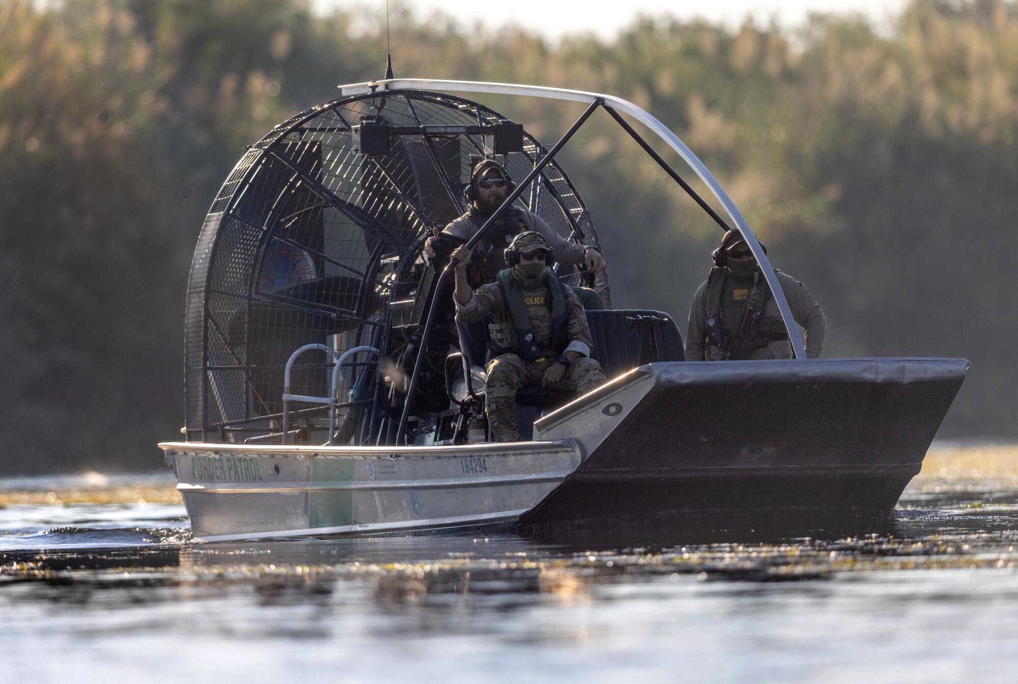 U.S. Border Patrol agents watch as Haitian immigrants cross the Rio Grande back into Mexico from Del Rio, Texas