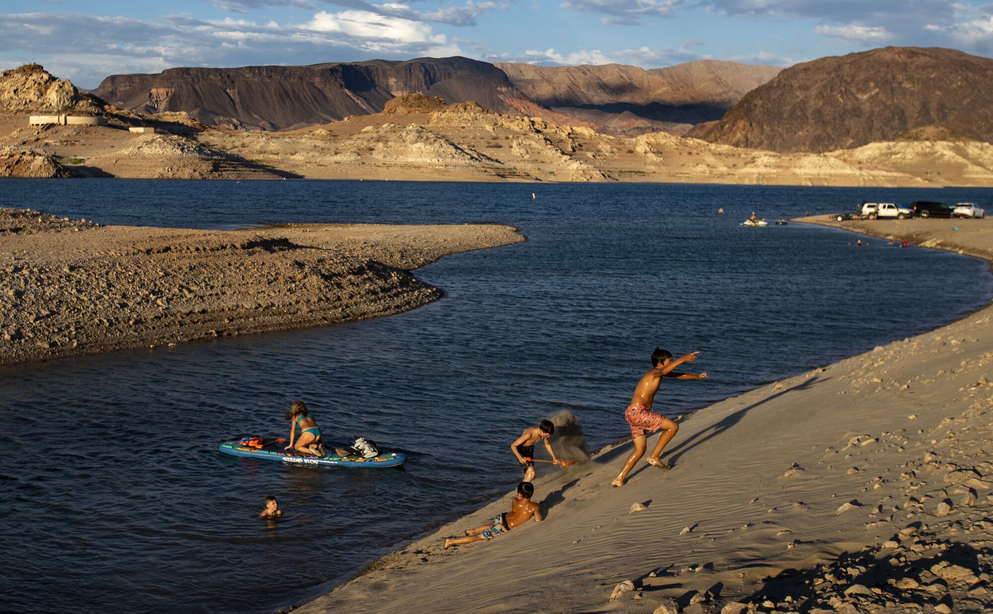 Children frolic on the shore lines of a lake